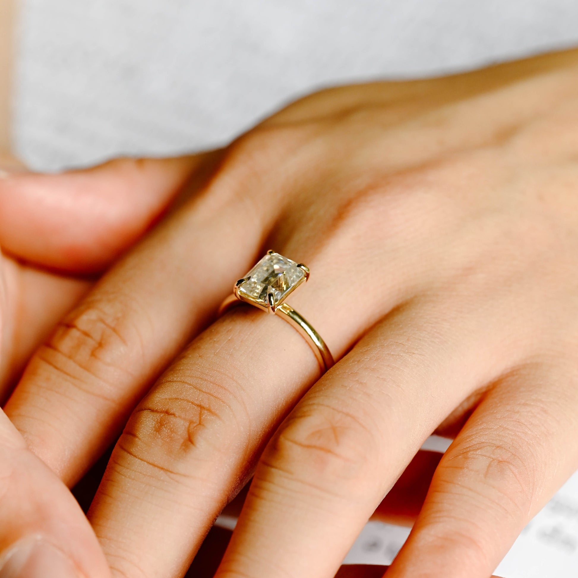 solid-gold-solitaire-emerald-cut-moissanite-engagement-ring