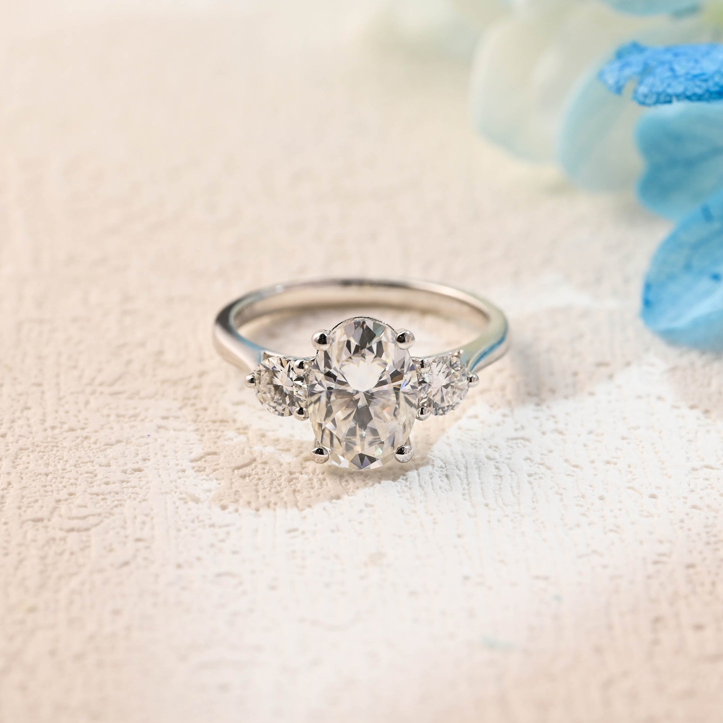 solid-gold-oval-moissanite-engagement-ring-cathedral-setting-side-stone-round-cut-three-stone-ring