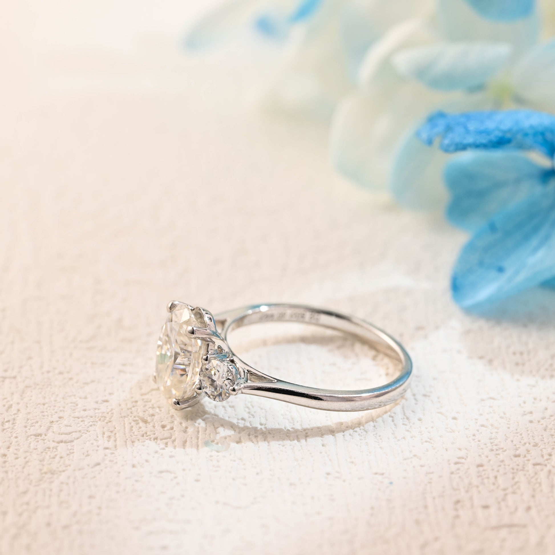 solid-gold-oval-moissanite-engagement-ring-cathedral-setting-side-stone-round-cut-three-stone-ring